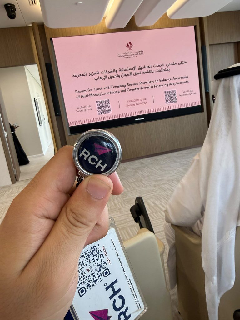RCH Qatar branded badge photographed in front of the presentation screen at the MoCI AML/CFT awareness forum.